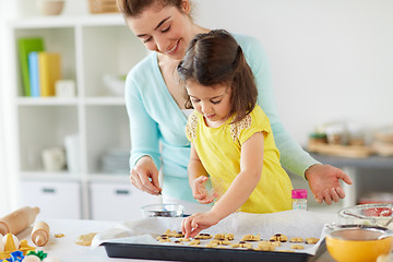 Image showing happy mother and daughter making cookies at home