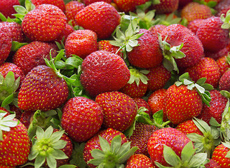 Image showing Background of beautiful and juicy strawberries with green leaves