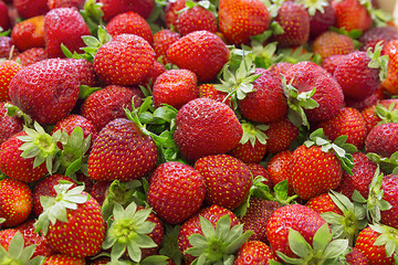 Image showing Background of beautiful and juicy strawberries with green leaves