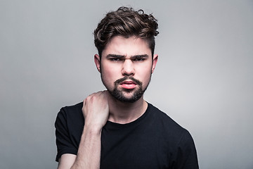 Image showing Young handsome man doubting on gray background 