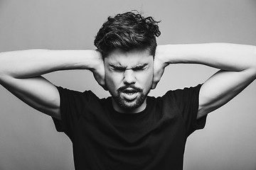 Image showing I need silence. Frustrated young man in shirt 