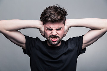 Image showing I need silence. Frustrated young man in shirt 