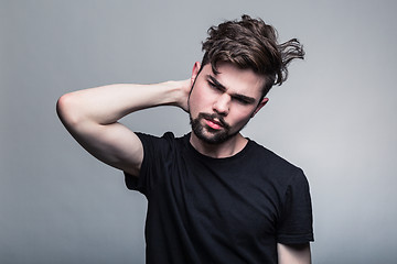 Image showing Young handsome man doubting on gray background 