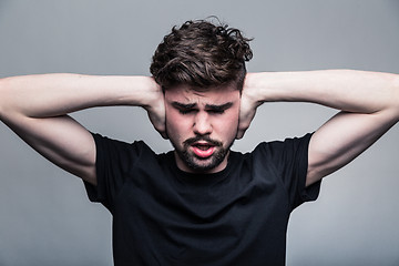 Image showing I need silence. Frustrated young man in shirt 