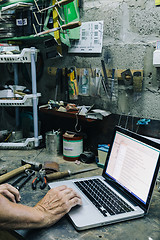 Image showing Unrecognizable mechanic working on laptop in garage