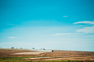 Image showing combine harvester on wheat field with  blue sky