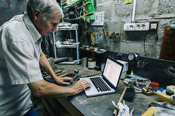 Image showing Senior man using laptop at workplace