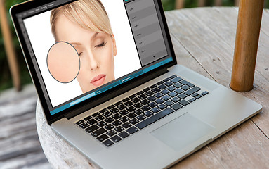Image showing laptop with woman face retouch in graphics editor
