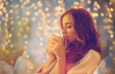 Image showing happy woman with cup of coffee in bed at home