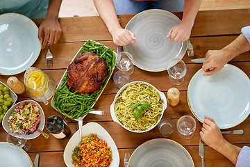 Image showing group of people with chicken and pasta on table