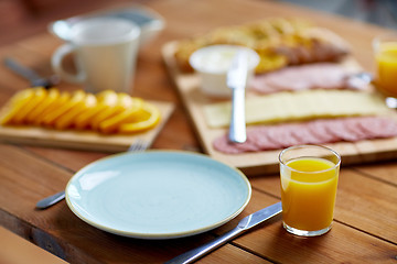 Image showing plate and glass of orange juice on table with food