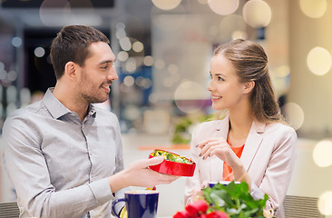 Image showing happy couple with present and flowers in mall