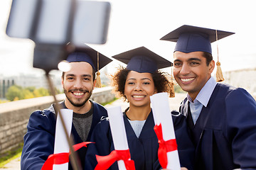 Image showing students or graduates with diplomas taking selfie