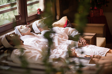 Image showing women is getting facial clay mask at spa