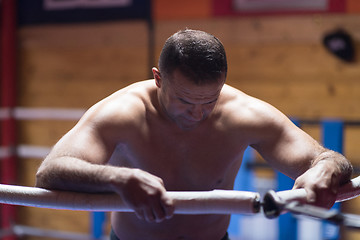 Image showing kick boxer resting on the ropes in the corner