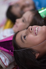 Image showing kids  blowing confetti while lying on the floor