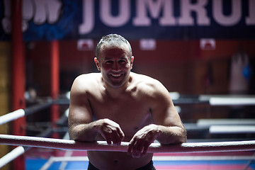 Image showing kick boxer resting on the ropes in the corner