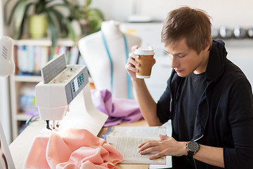 Image showing fashion designer with coffee and book at studio