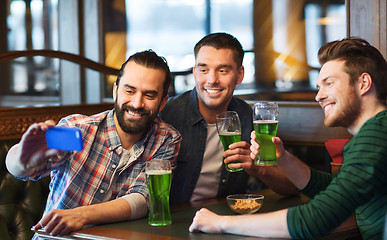 Image showing friends taking selfie with green beer at pub