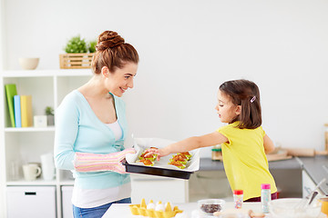 Image showing mother and daughter baking muffins at home