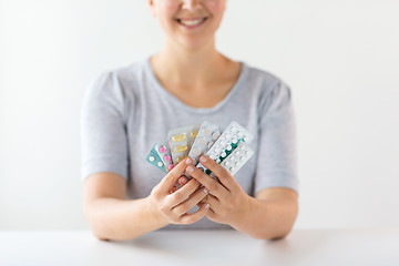 Image showing happy woman holding packs of pills