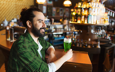 Image showing man drinking green beer at bar or pub