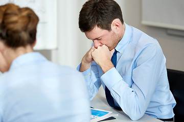 Image showing upset or anxious businessman with report at office