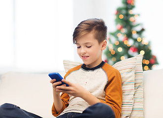 Image showing boy playing on smartphone at home at christmas