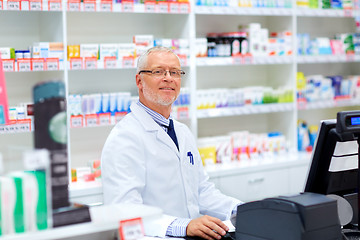 Image showing senior apothecary at pharmacy cash register