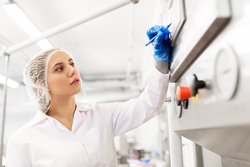 Image showing woman programming computer at ice cream factory