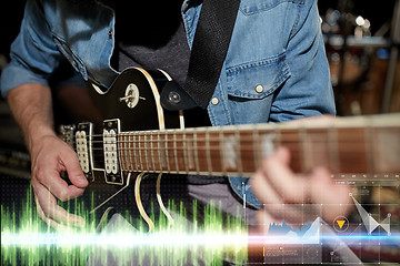 Image showing close up of musician playing guitar at studio