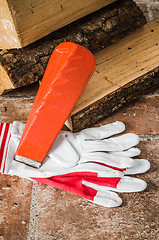 Image showing Saw, mittens and firewood, close-up