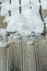 Image showing Melting snow on a wooden terrace, close-up