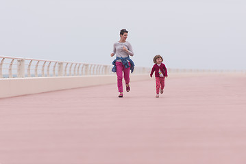 Image showing mother and cute little girl on the promenade by the sea