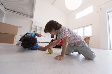 Image showing boys having fun with an apple on the floor