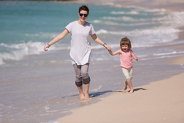 Image showing mother and daughter running on the beach