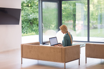 Image showing Young woman using laptop at home