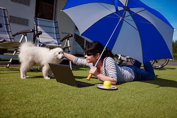 Image showing Woman on the grass with a dog looking at a laptop