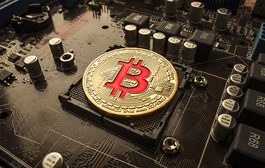 Image showing Gold Bit Coin BTC coins on the motherboard. Bitcoin is a worldwi