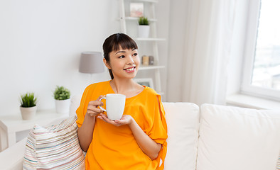 Image showing happy asian woman drinking tea or coffee at home