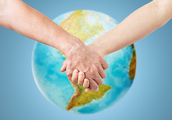 Image showing close up of senior and young woman holding hands