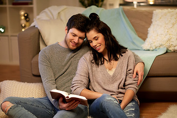 Image showing happy couple reading book at home