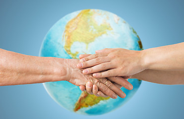 Image showing close up of senior and young woman holding hands