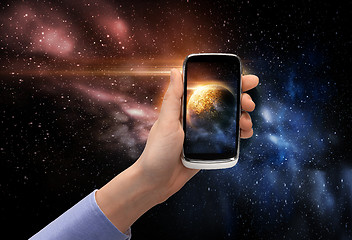 Image showing hand with planet on smartphone screen over space