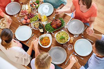 Image showing group of people at table praying before meal