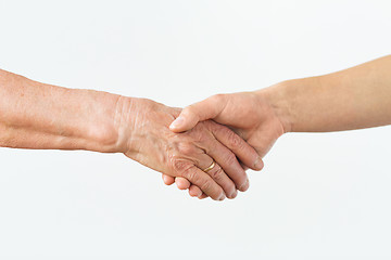 Image showing close up of senior and young woman holding hands