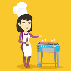 Image showing Woman cooking steak on barbecue grill.