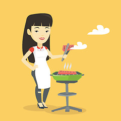 Image showing Woman cooking steak on barbecue grill.