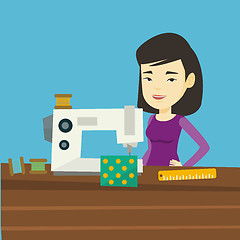 Image showing Seamstress using sewing machine at workshop.