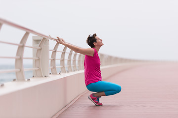 Image showing woman stretching and warming up on the promenade